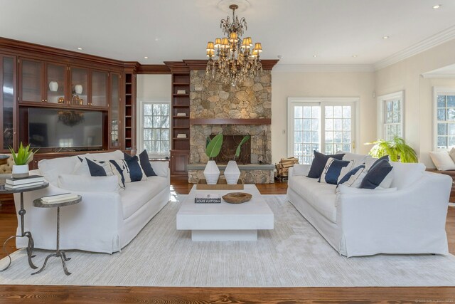 living room featuring light wood-style flooring, a fireplace, and ornamental molding