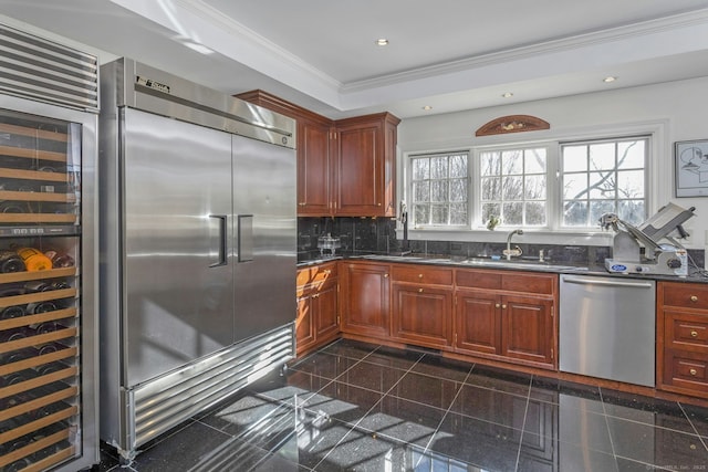 kitchen with dark countertops, appliances with stainless steel finishes, ornamental molding, granite finish floor, and recessed lighting