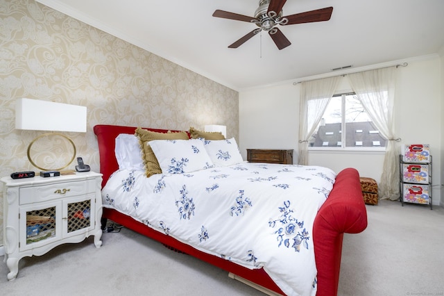 bedroom with carpet floors, visible vents, ornamental molding, ceiling fan, and wallpapered walls