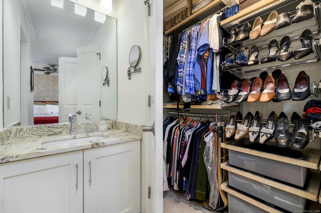 walk in closet featuring a sink and a ceiling fan