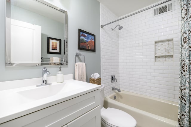 bathroom featuring toilet, vanity, shower / bath combination with curtain, and visible vents