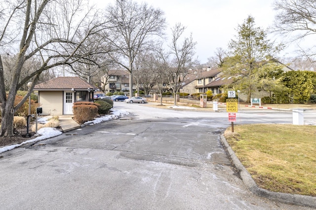 view of road with traffic signs, a residential view, and curbs