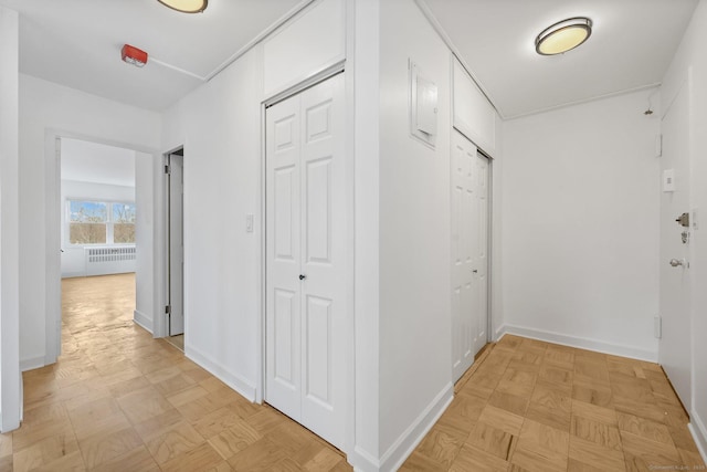 hall with radiator heating unit and baseboards