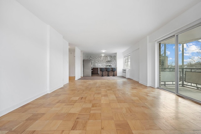 unfurnished living room featuring baseboards