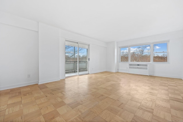 empty room with radiator and baseboards