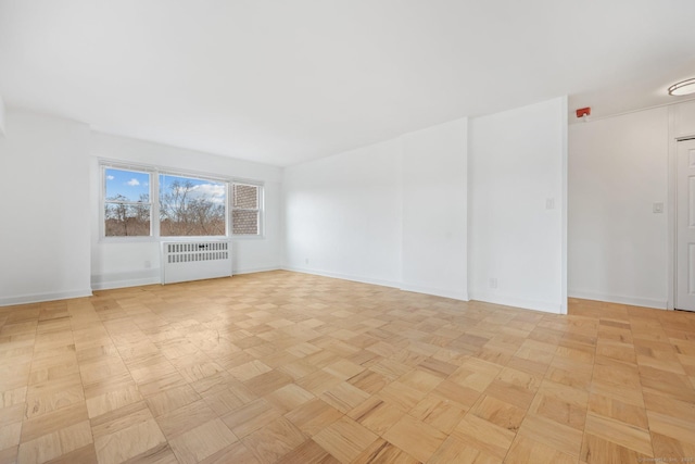 spare room featuring baseboards and radiator heating unit