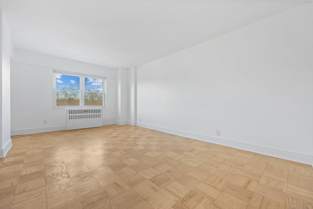 unfurnished room featuring radiator heating unit and baseboards