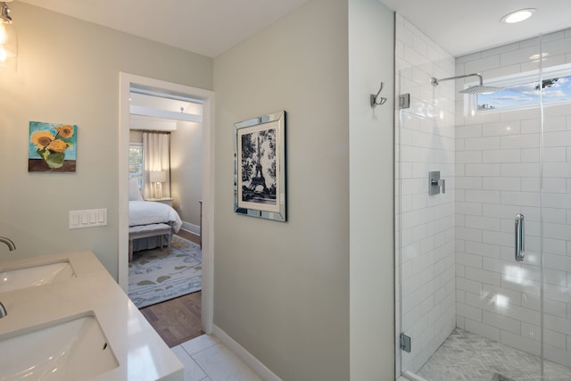 ensuite bathroom with a stall shower, plenty of natural light, and a sink