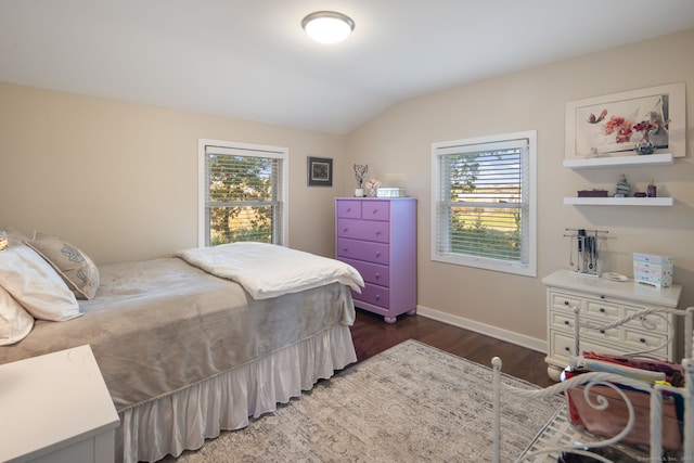 bedroom featuring dark wood-type flooring, lofted ceiling, multiple windows, and baseboards