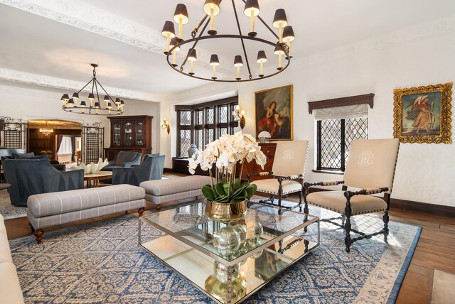 living area with baseboards, wood finished floors, and an inviting chandelier