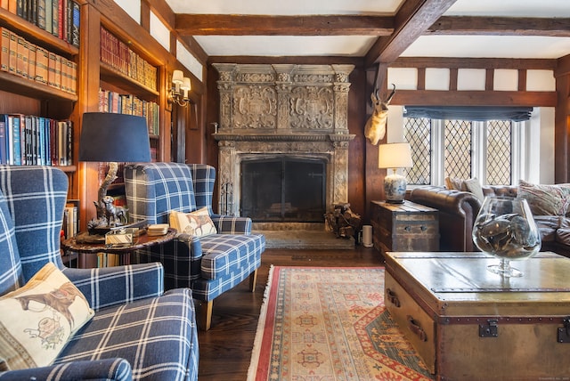 living area with a premium fireplace, wood finished floors, and beamed ceiling