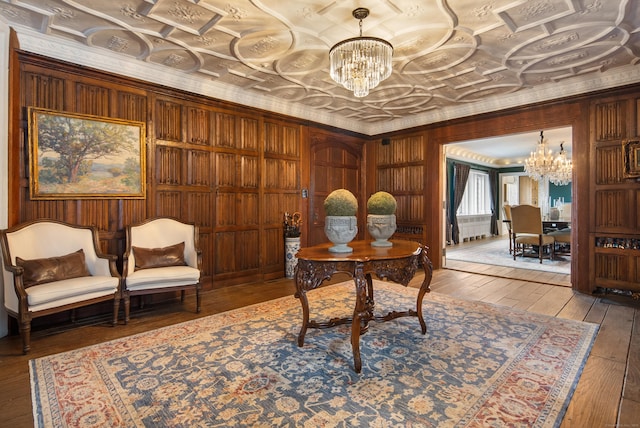 office space featuring an ornate ceiling, a chandelier, ornamental molding, and hardwood / wood-style floors