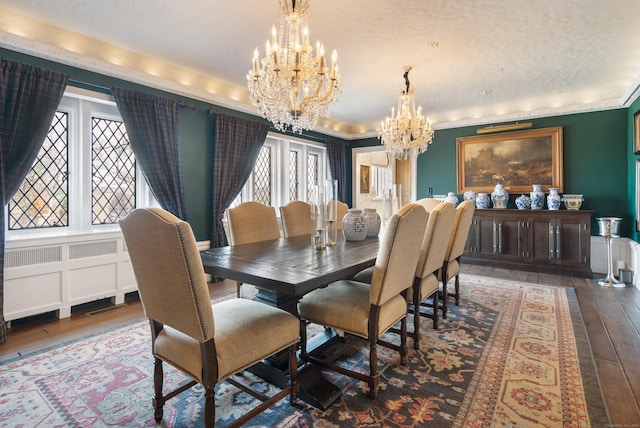 dining room with a chandelier, ornamental molding, and hardwood / wood-style flooring