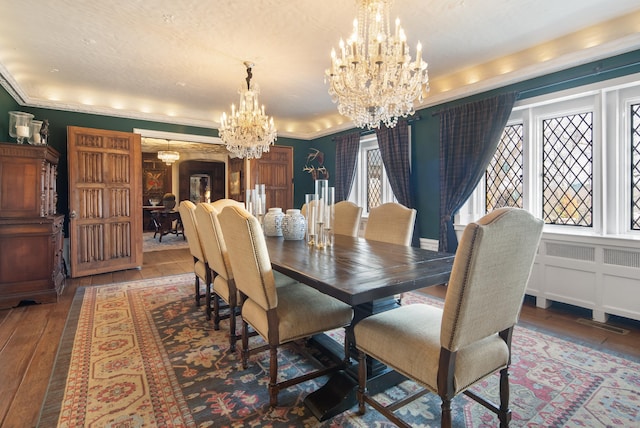 dining space featuring a chandelier, arched walkways, wood-type flooring, and crown molding