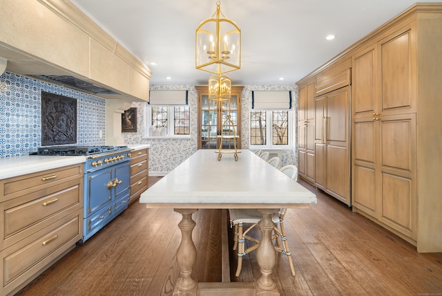 kitchen featuring dark wood-style flooring, light countertops, a kitchen island, premium range hood, and range