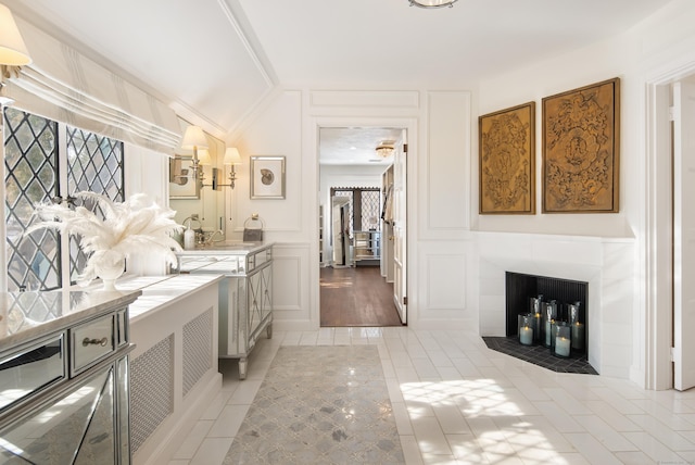 laundry area featuring light tile patterned floors, a fireplace, and a decorative wall