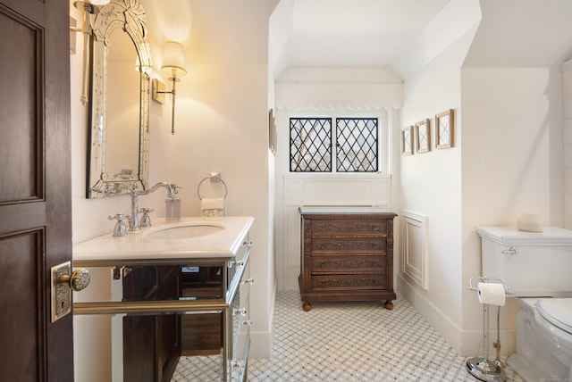 bathroom featuring lofted ceiling, vanity, and toilet