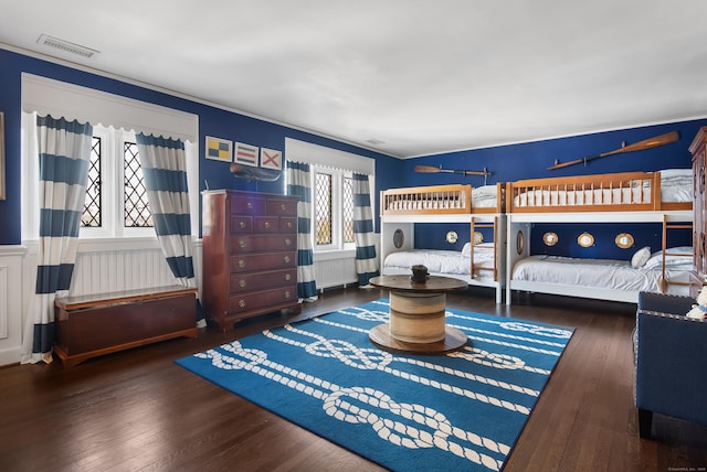 bedroom featuring wainscoting, visible vents, and hardwood / wood-style floors