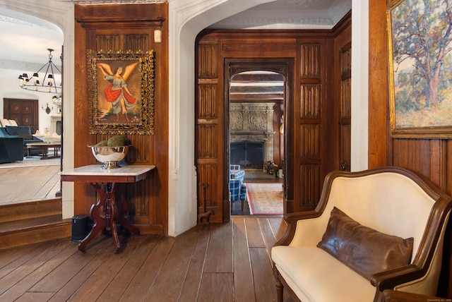 interior space with a fireplace, wood walls, hardwood / wood-style floors, and an inviting chandelier