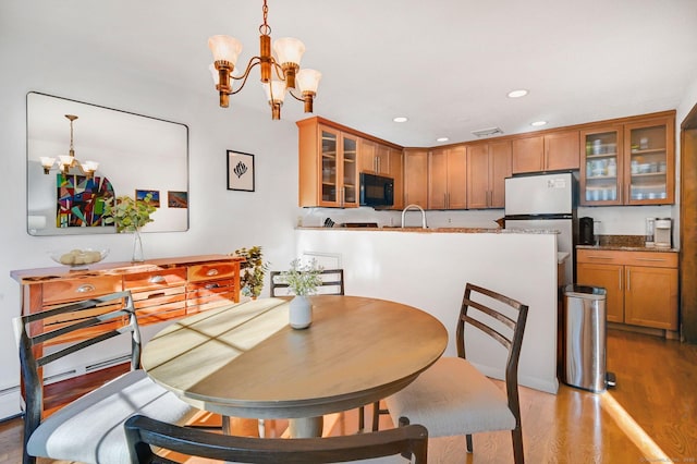 dining area featuring recessed lighting, visible vents, a notable chandelier, and wood finished floors