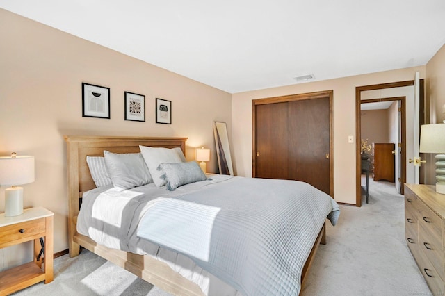 bedroom featuring light carpet, a closet, and baseboards