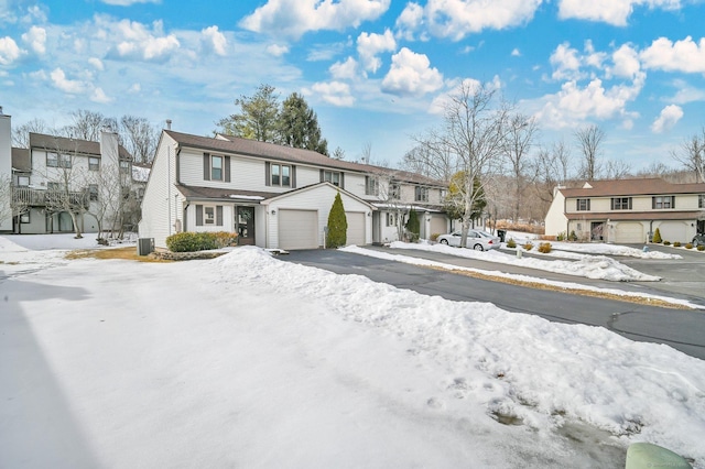 view of property with a garage, a residential view, and driveway