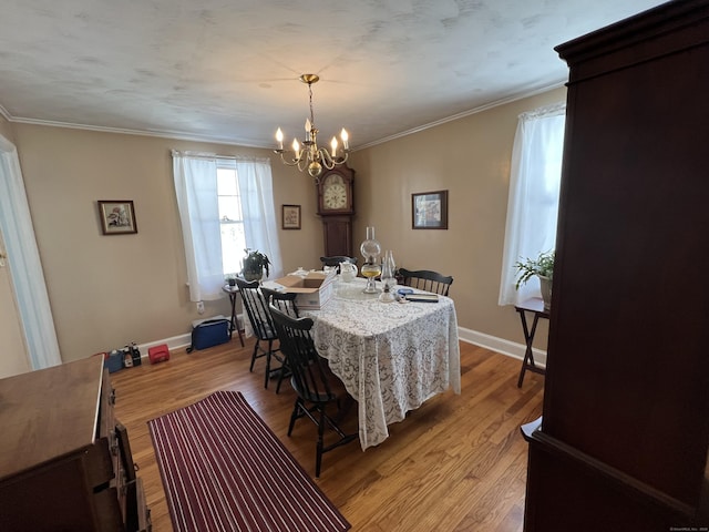 dining area with ornamental molding, baseboards, and light wood finished floors