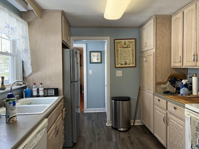 kitchen featuring white appliances, baseboards, dark wood-type flooring, light brown cabinetry, and a sink