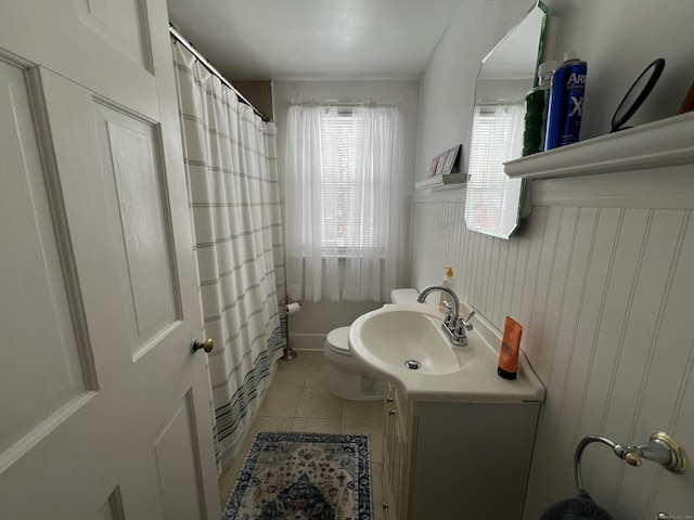 bathroom with wainscoting, toilet, a shower with curtain, tile patterned flooring, and vanity