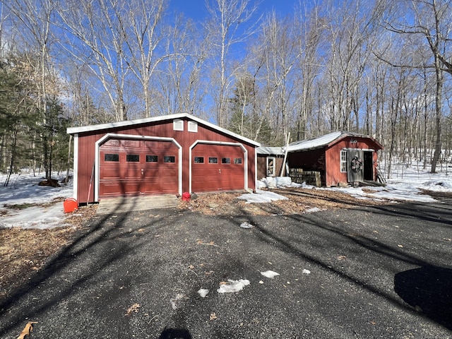 snow covered garage with driveway