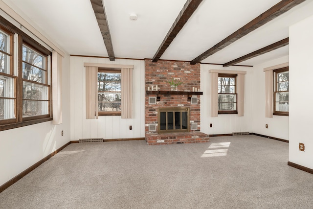 unfurnished living room with a wealth of natural light, visible vents, beam ceiling, and a brick fireplace