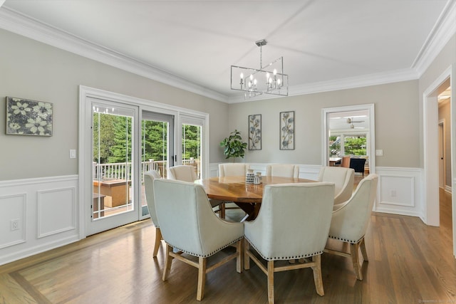 dining area with a healthy amount of sunlight, a wainscoted wall, and wood finished floors