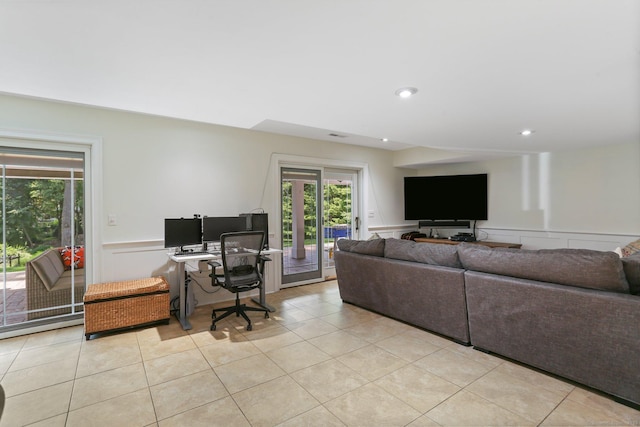 living room featuring a wealth of natural light, a wainscoted wall, and light tile patterned floors