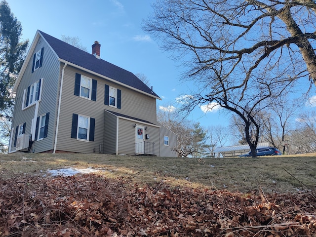 view of front of property featuring roof with shingles and a chimney