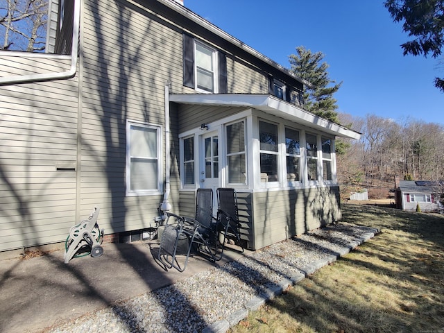 view of side of home with a patio and a sunroom