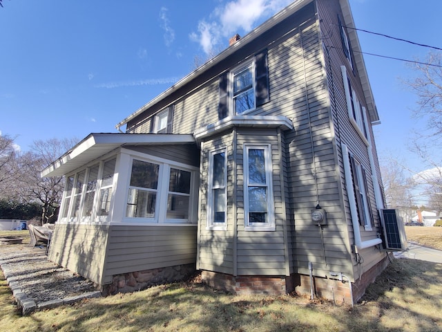 view of side of property with a chimney and a sunroom