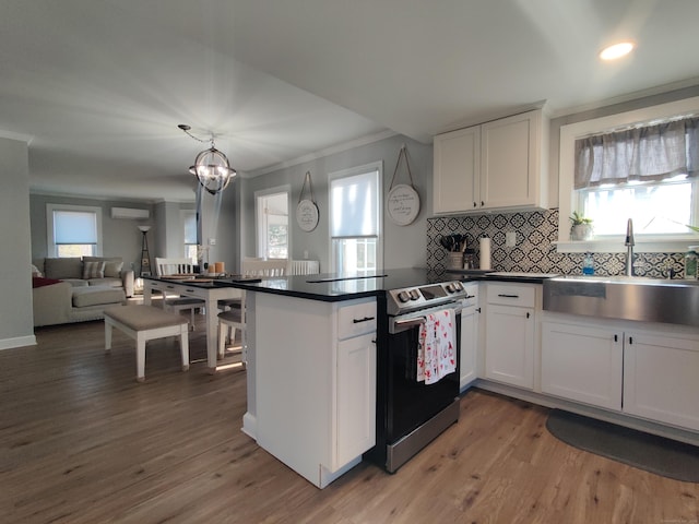 kitchen with dark countertops, a sink, white cabinetry, and stainless steel range with electric cooktop