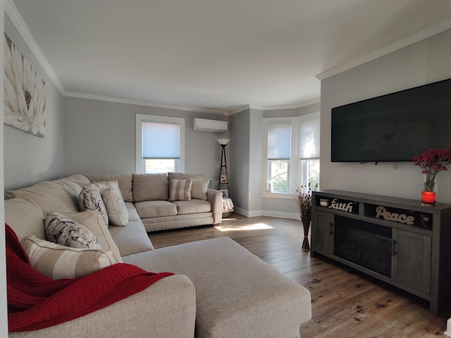 living area with ornamental molding, a wall mounted air conditioner, baseboards, and wood finished floors