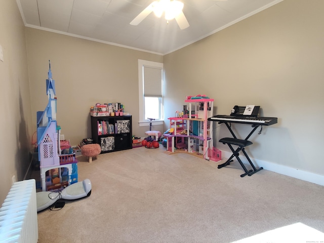 playroom featuring carpet floors, radiator heating unit, ornamental molding, and ceiling fan