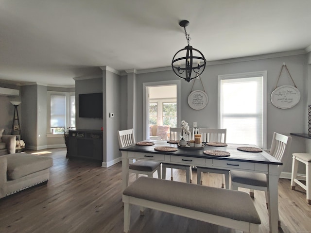 dining area with baseboards, a notable chandelier, wood finished floors, and crown molding