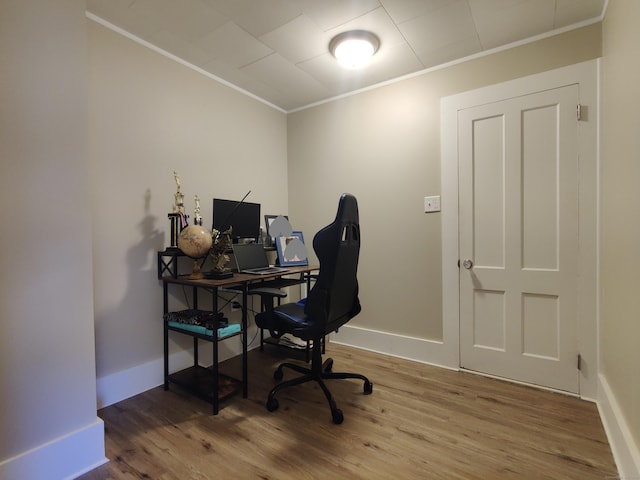 office area with baseboards, crown molding, and wood finished floors