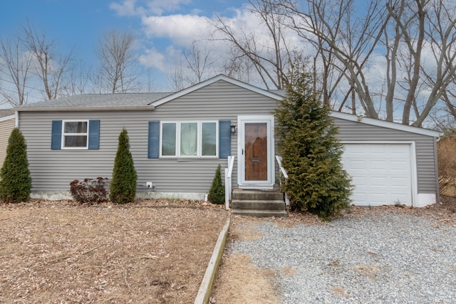 view of front of home with gravel driveway and roof with shingles