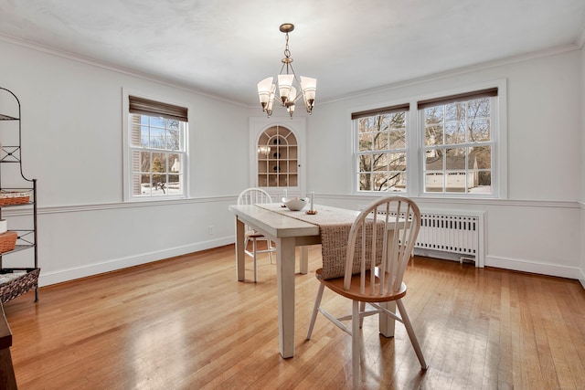 dining area with light wood finished floors, baseboards, and ornamental molding