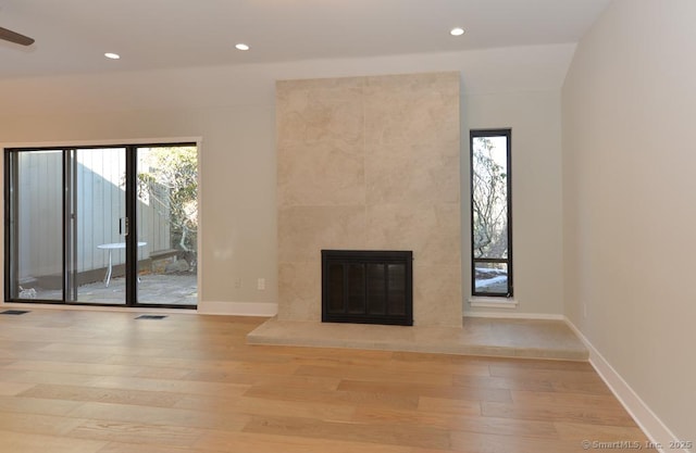 unfurnished living room featuring light wood-type flooring, baseboards, a fireplace, and visible vents