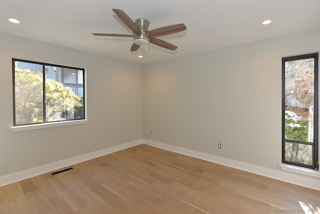 spare room featuring a wealth of natural light, visible vents, and light wood-style flooring