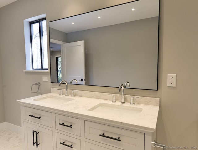 bathroom featuring double vanity, recessed lighting, and a sink