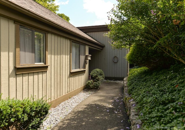 view of side of home with a shingled roof