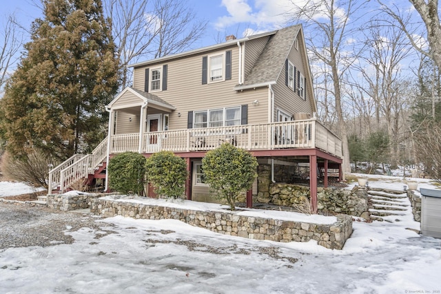 view of front of home featuring roof with shingles, a chimney, and stairs