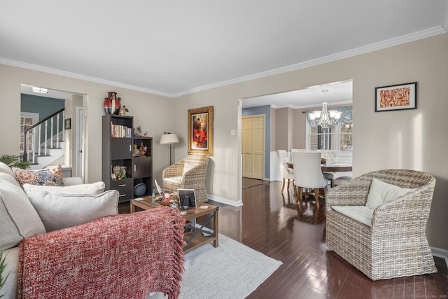 living room with ornamental molding, an inviting chandelier, hardwood / wood-style flooring, and baseboards