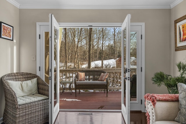 doorway to outside with french doors, crown molding, and wood finished floors